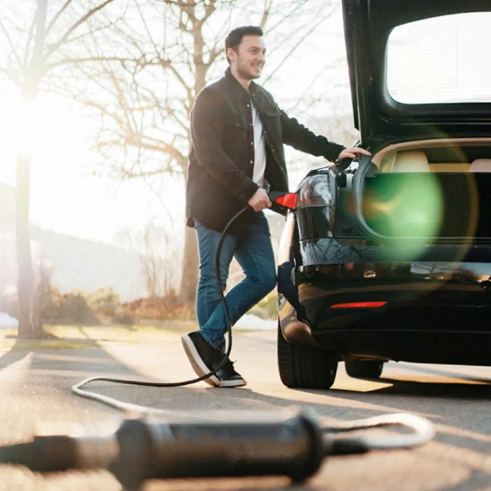 Auto eléctrico cargando con el cargador portátil J+ Booster 2