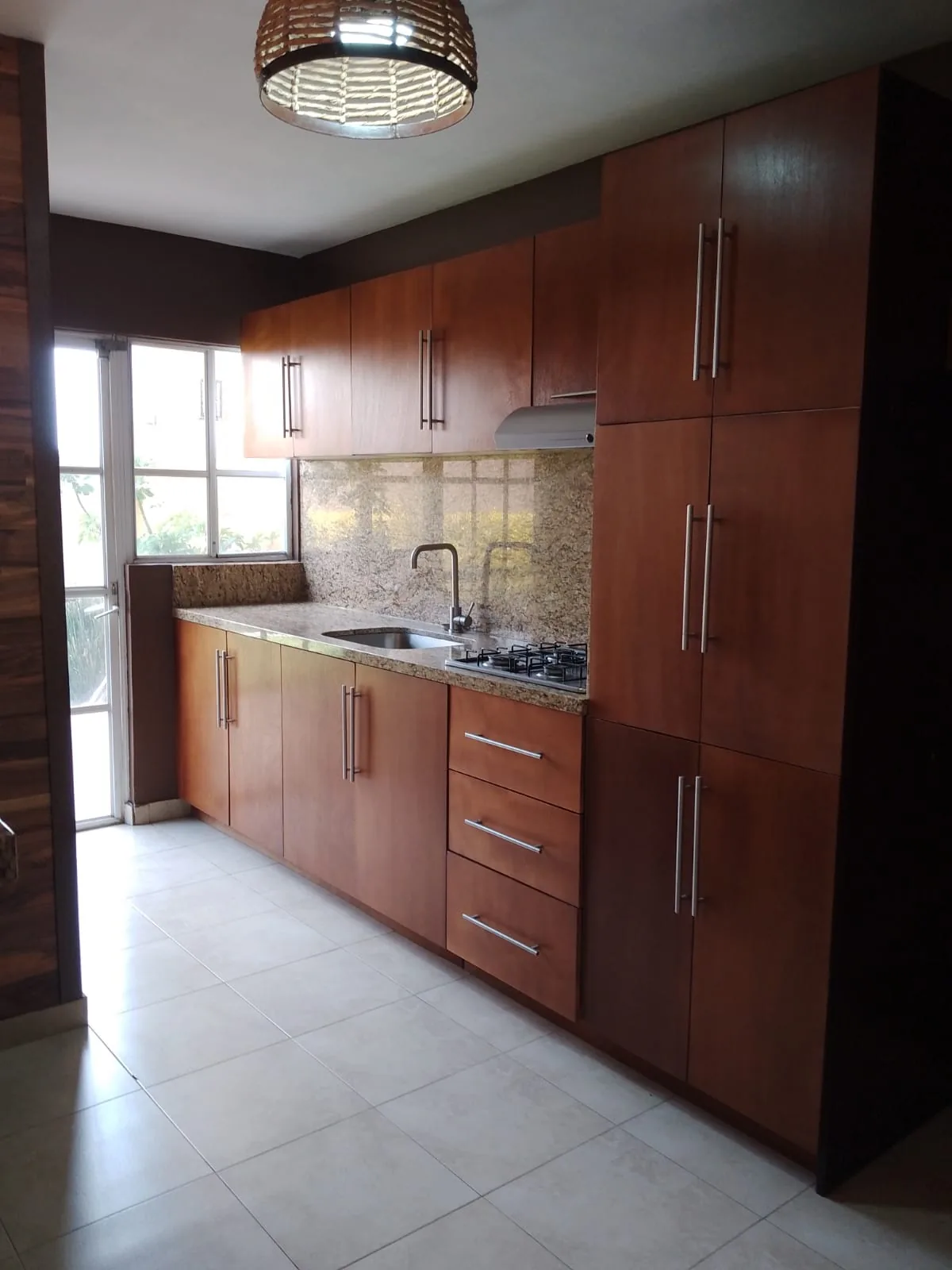 Cocina equipada con cubierta de granito y acceso al patio de servicio