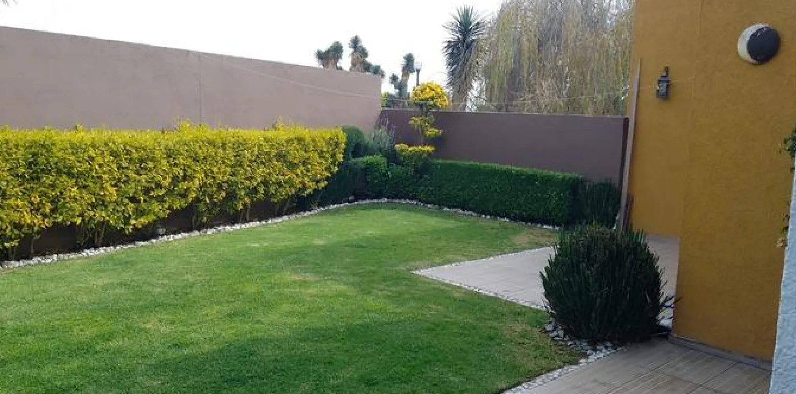 Jardín privado con terraza y acceso desde la sala